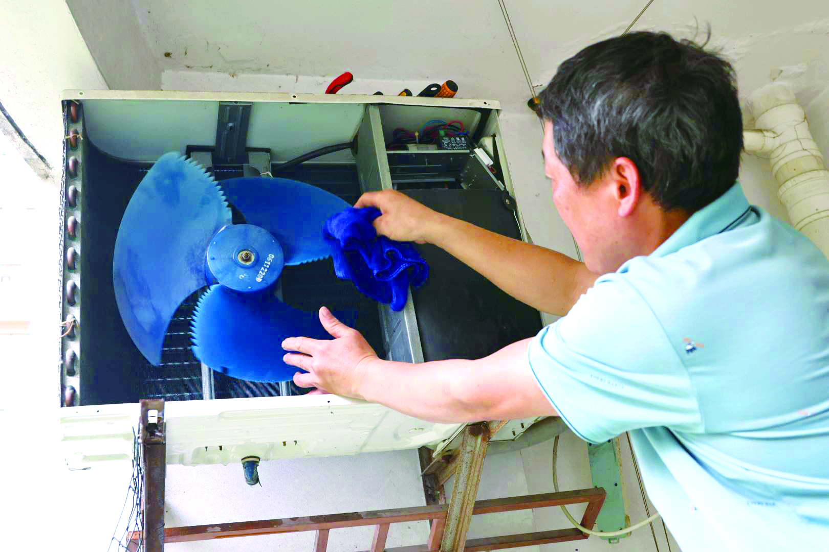 5月21日,城区果园三路家电维修部的王师傅上门服务,为客户清洗空调.