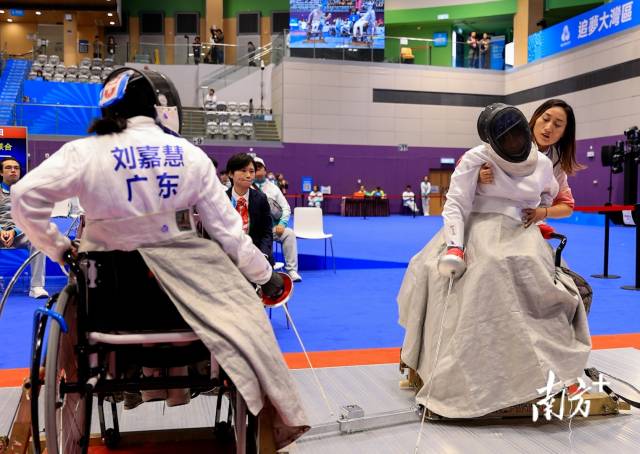 C级运动员江柏莹在出剑时因肌张力不足致倒下后无法自行复位，一旁的随队主管王帆见状立刻一个箭步冲上前将她扶起。