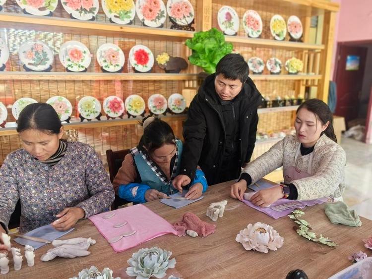 Artisan Li Changsuo teaches apprentices how to craft porcelain pieces shaped like peonies at a peony porcelain workshop in Malinggang Town of Heze City, east China's Shandong Province, Feb. 19, 2026. (Photo by Wang Yan/Xinhua)