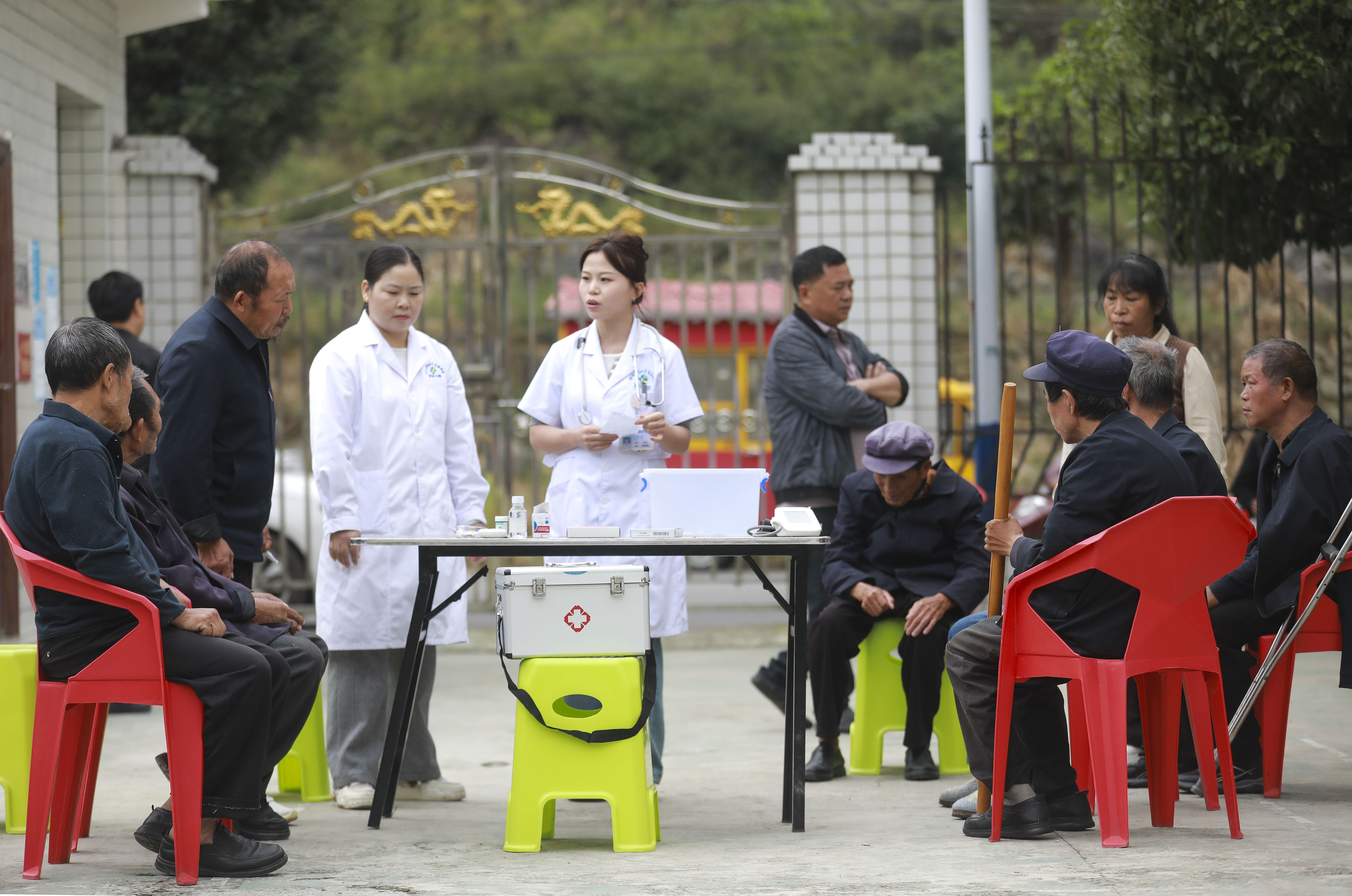 2026年10月13日,贵州黔西,医务人员在定新彝族苗族乡敬老院,给老人讲解慢性病日常养护知识。